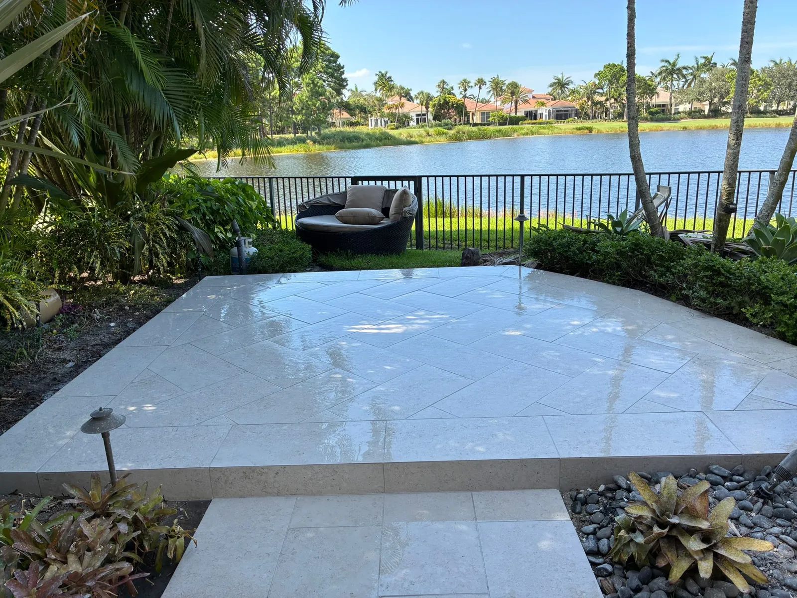 Raised limestone paver patio in a herringbone layout overlooking a lake and golf course.