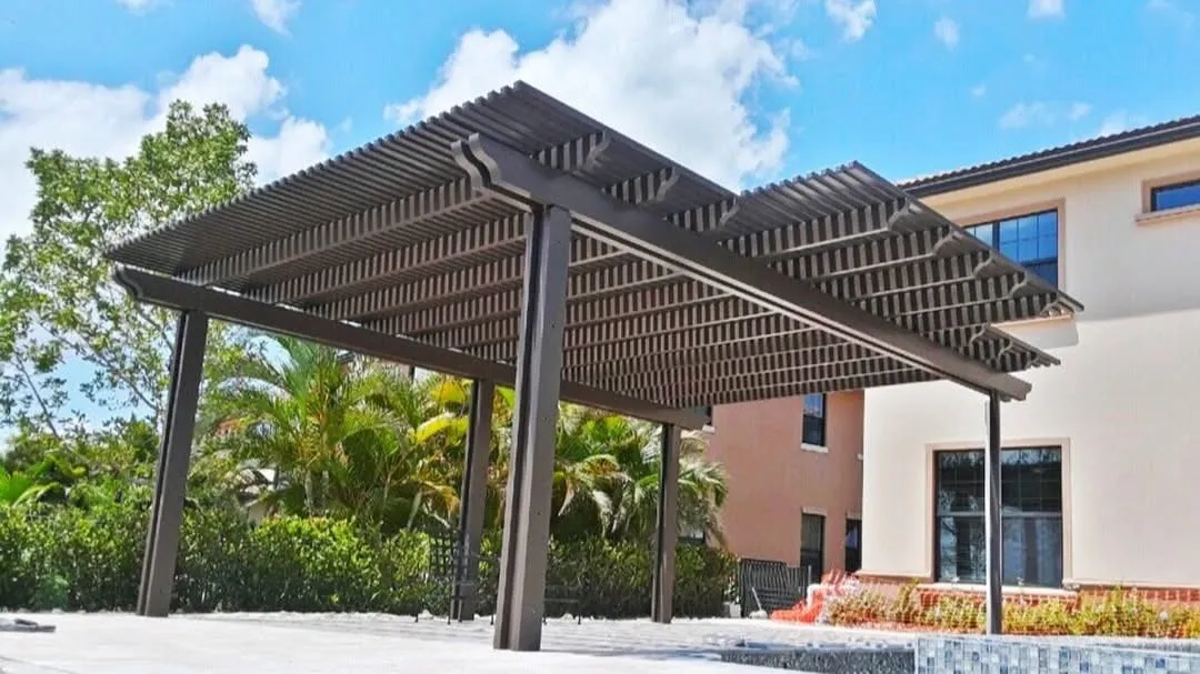 Bronze freestanding two-tier lattice pergola with scalloped beam ends beside a pool and two-story home