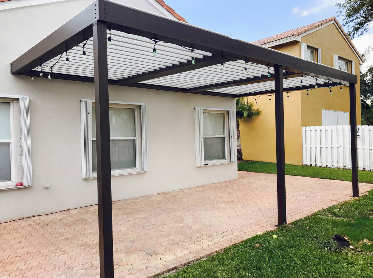 Motorized louvered roof installed over patio, providing adjustable shade, ventilation, and weather protection in Florida homes.