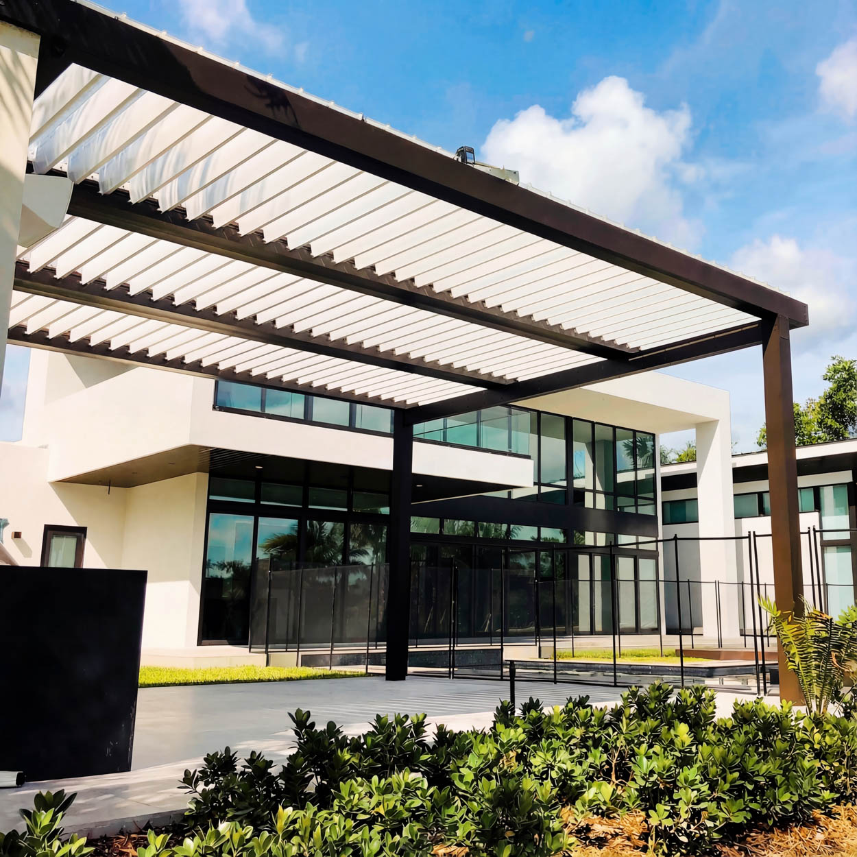 Custom patio cover with integrated LED lighting and motorized louvers for day and night outdoor comfort in Florida.
