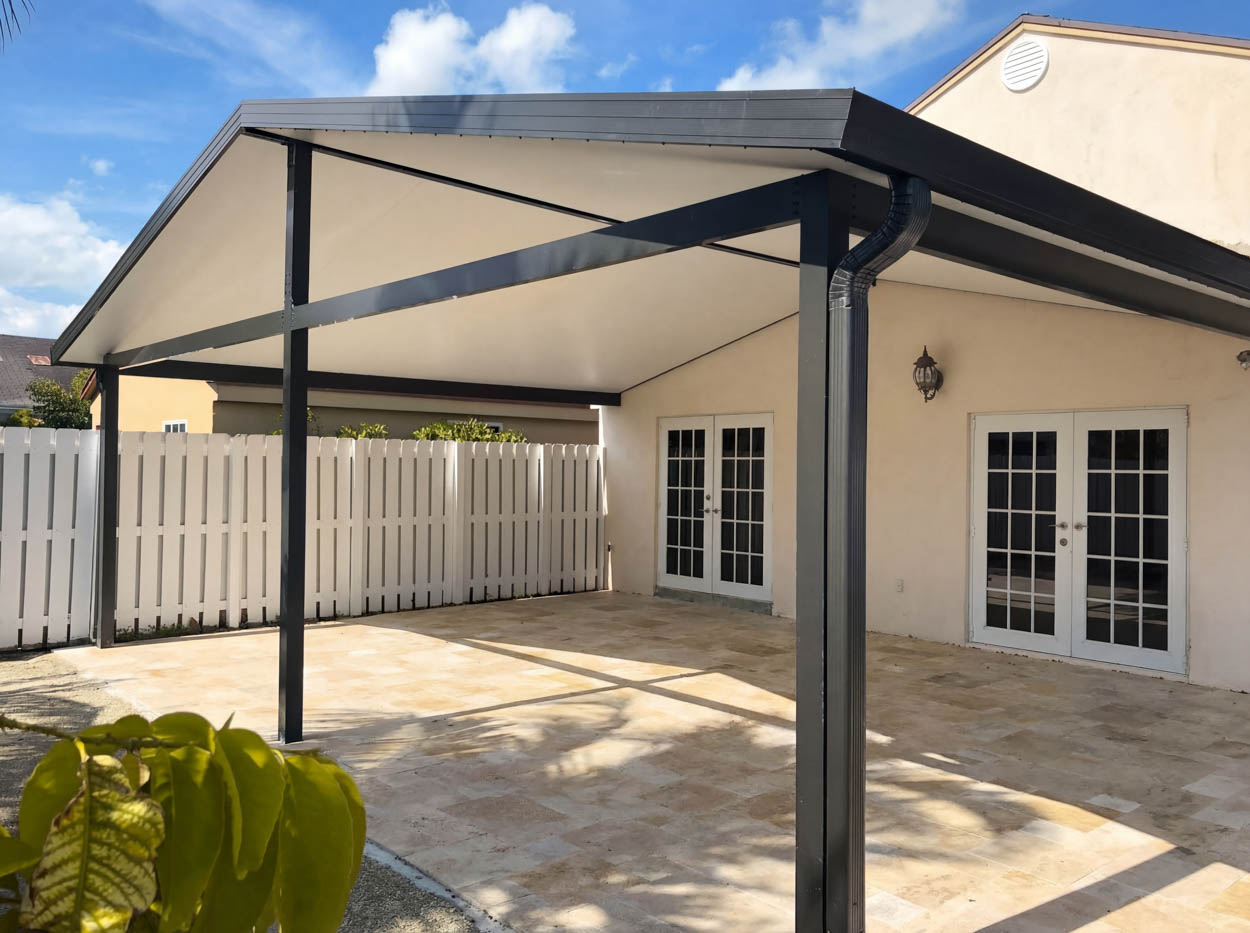 Custom aluminum patio cover installation by Florida pergola builders, providing shaded outdoor living space with modern structure.