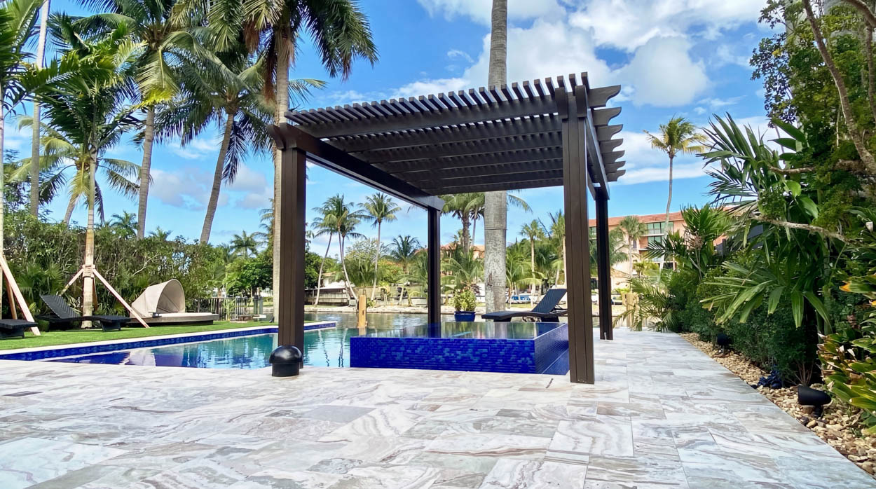 Aluminum pergola installation over pool area by Florida contractors, providing shade and modern outdoor design.