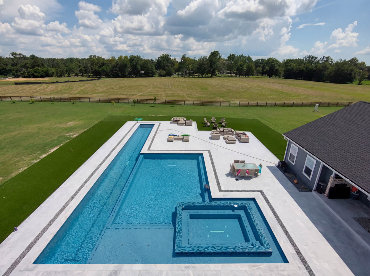 Large custom pool and spa design with expansive deck and seating areas, built by expert pool builders in North Florida.