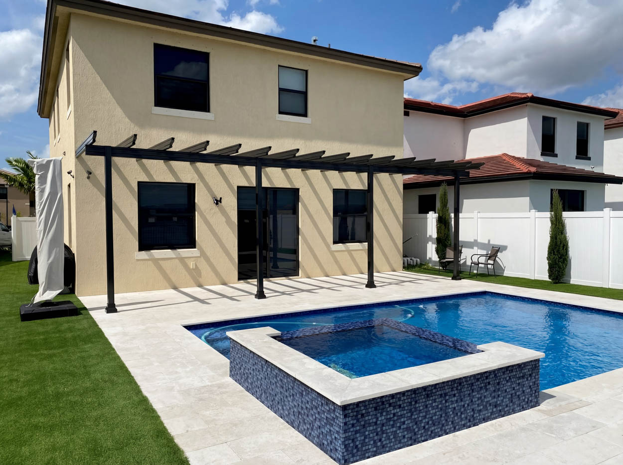 Resort-style pool with tanning ledges and water features, showcasing custom pool construction in South Florida.