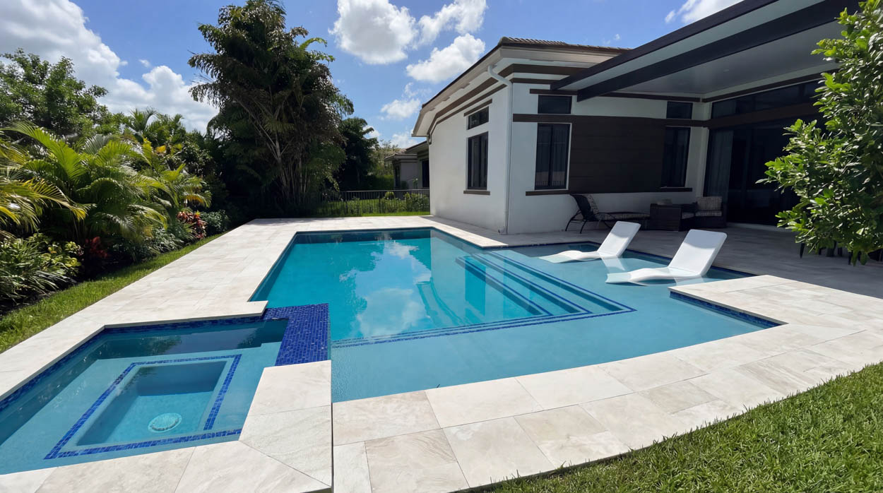 Custom inground pool installation with pergola and safety fencing, built by licensed Florida pool builders.