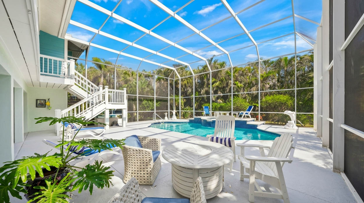 Custom pool enclosure with curved pool design and patio installed by expert pool screen contractors in Florida.