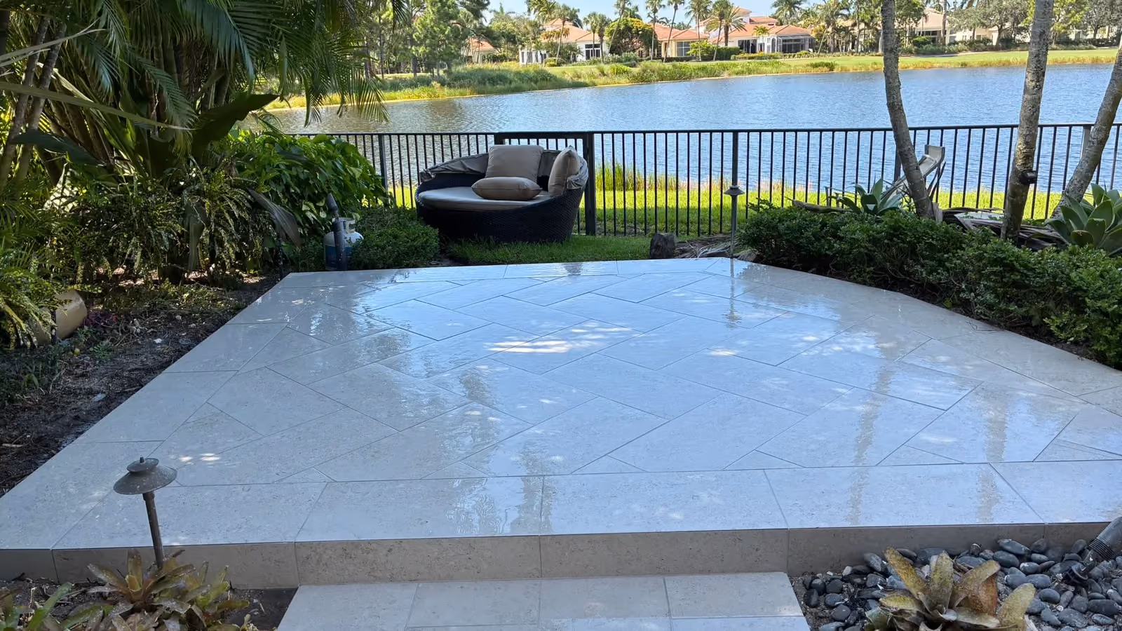 Raised limestone paver patio in a herringbone layout overlooking a lake and golf course.