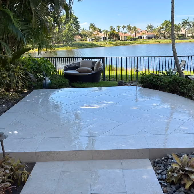 Raised limestone paver patio in a herringbone layout overlooking a lake and golf course.