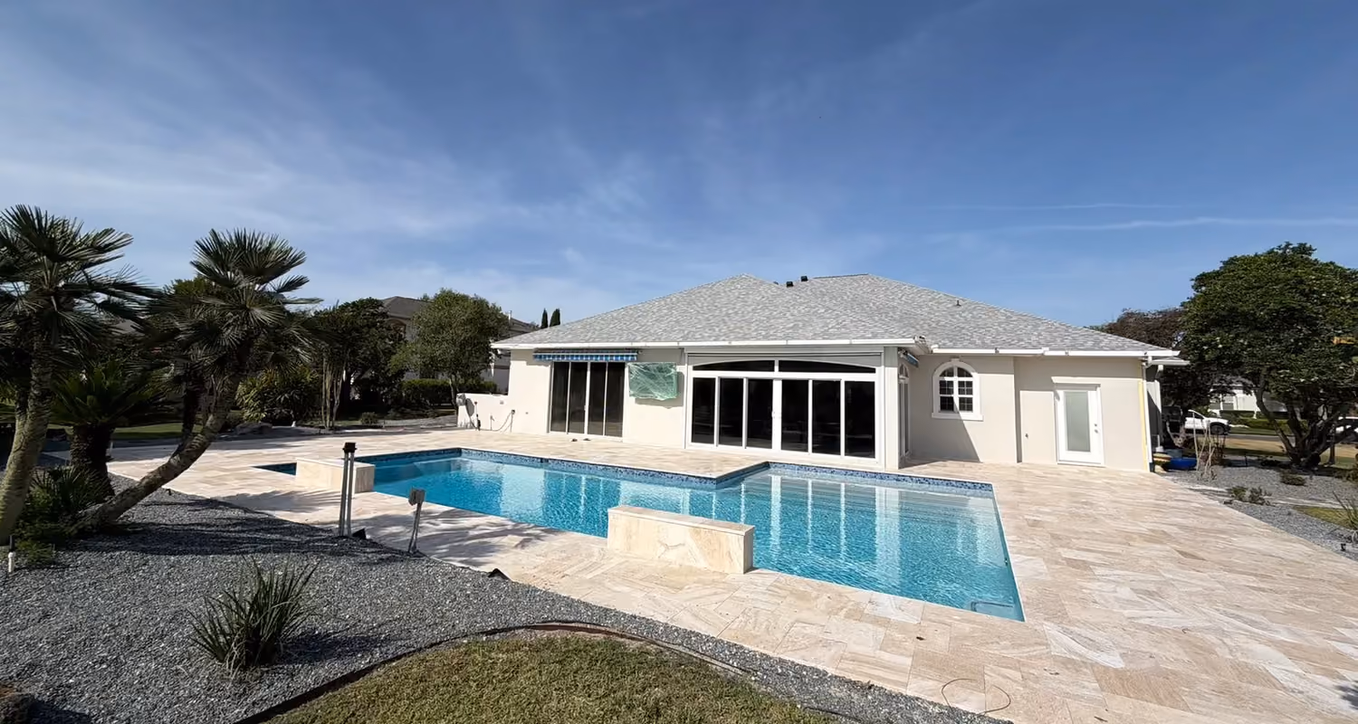 Remodeled rectangular pool with two travertine water feature walls and a large travertine deck.