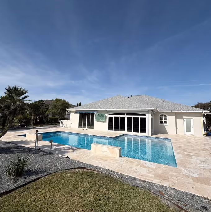 Remodeled rectangular pool with two travertine water feature walls and a large travertine deck.