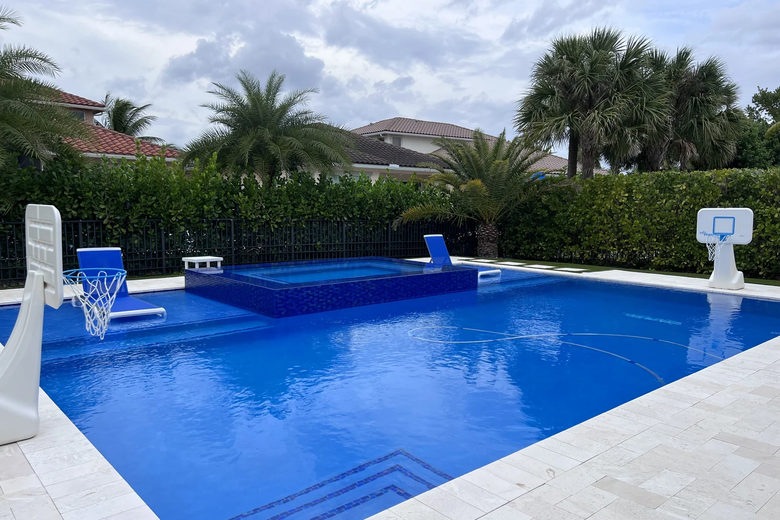 Completed backyard pool with raised spa and poolside basketball hoop