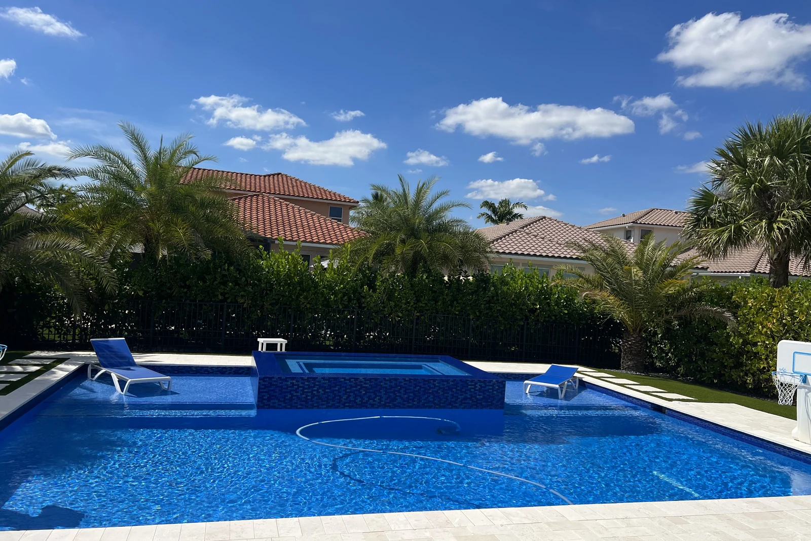 Completed backyard pool with a raised spa clad in glass mosaic