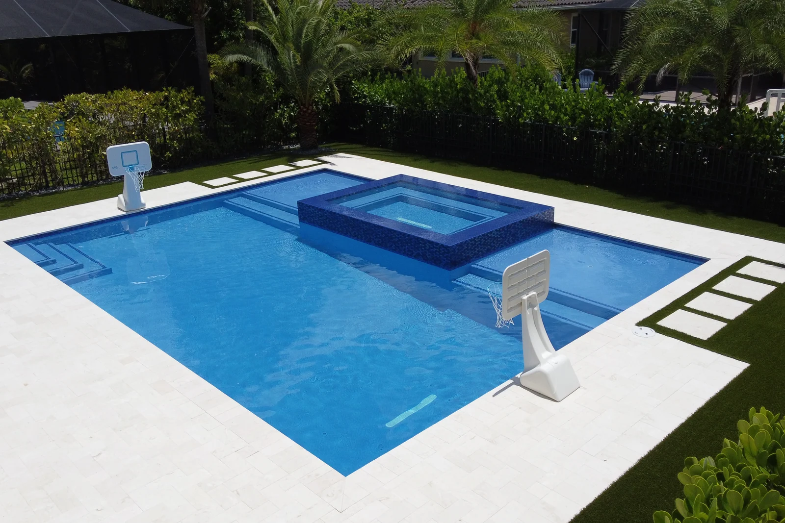 Aerial view of a backyard pool with raised spa