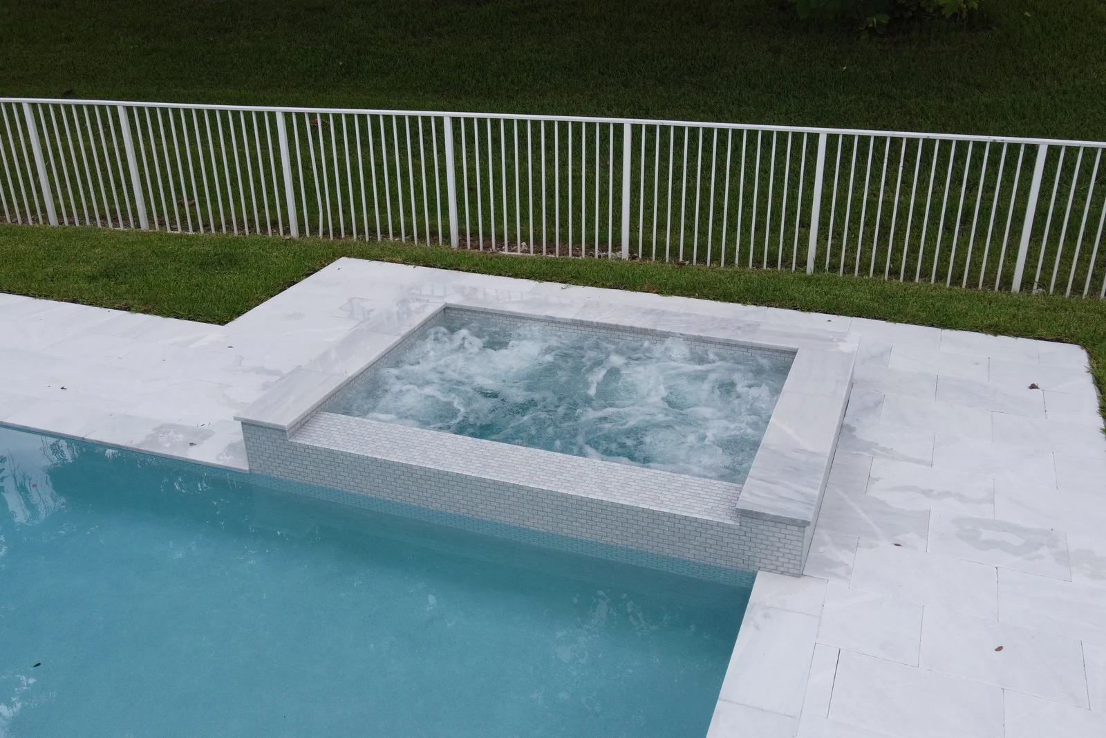 Aerial view of a backyard pool with raised spa and aluminium picket fence