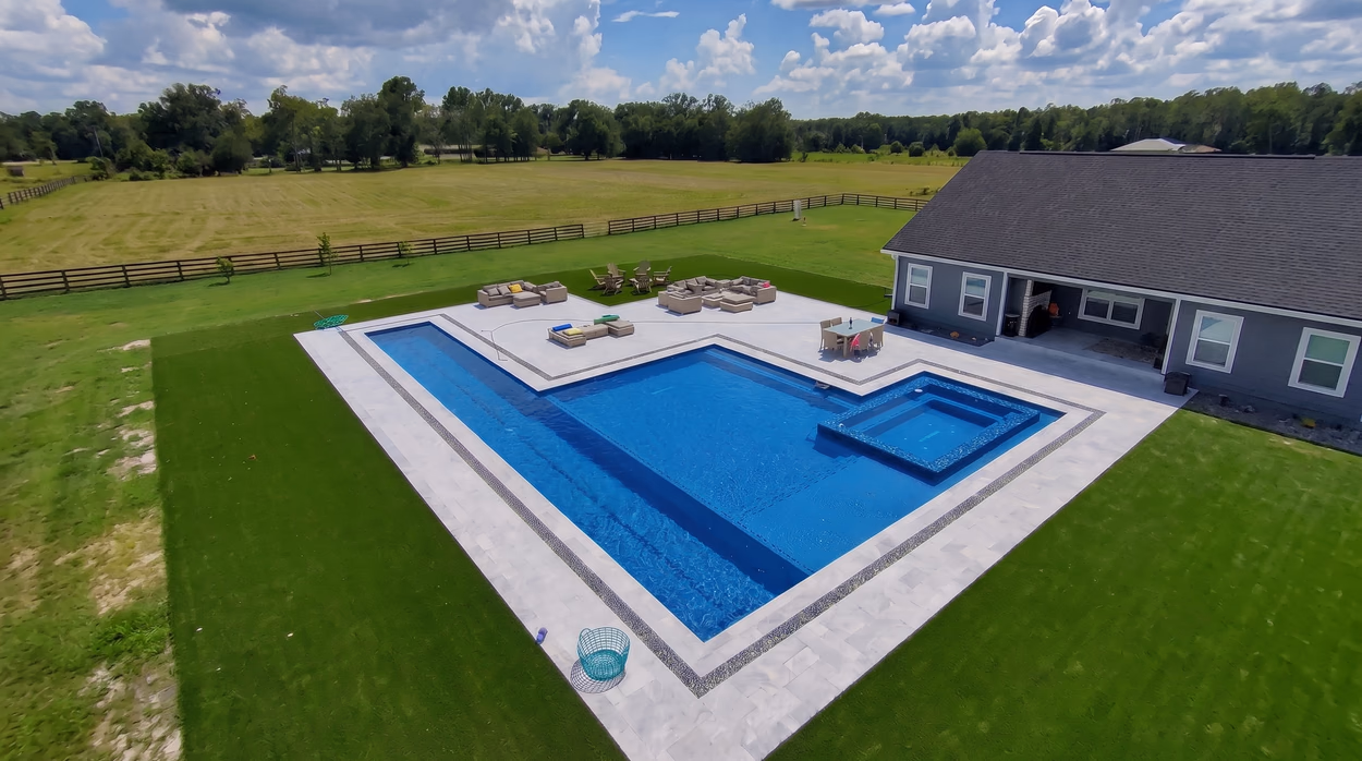 The full property from the pasture side, with the pool, the lounge area and the single-story home.