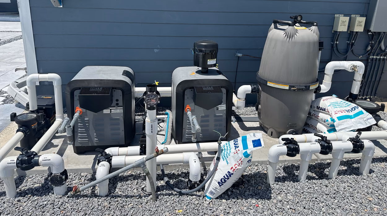 Pool equipment pad with two heaters, a cartridge filter, pump and PVC valve manifold at a Florida home