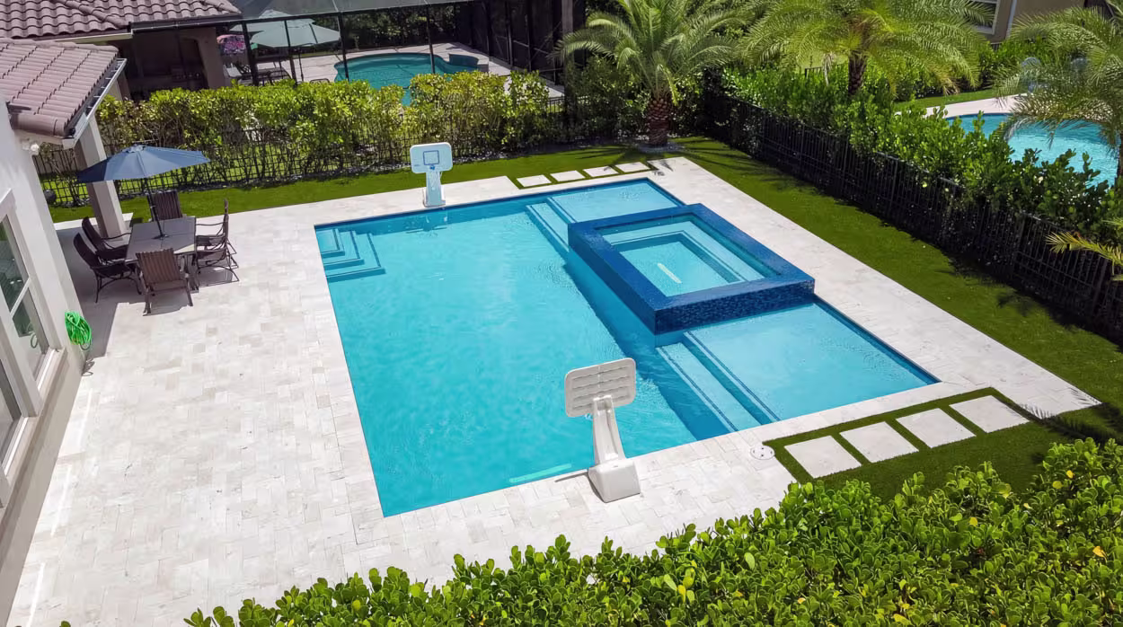Luxury custom pool design in South Florida with modern geometric layout, premium stone decking, and resort-style backyard built by expert pool builders.